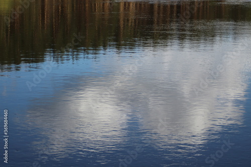 The Bay of the river. Landscape with a river and forest in the background. Reflection of the sky in the water