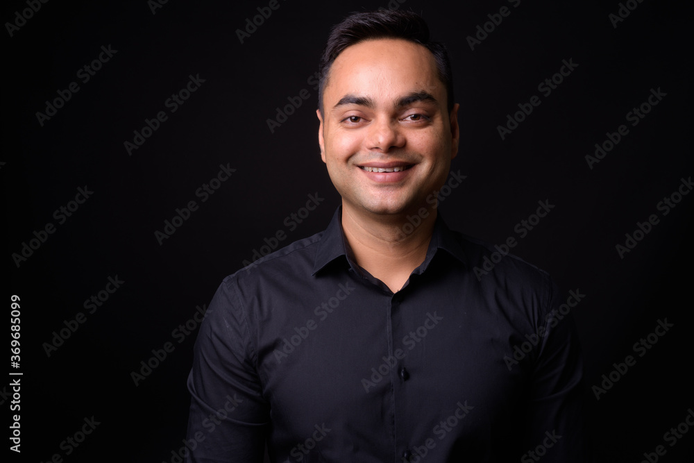 Portrait of happy young handsome Indian businessman