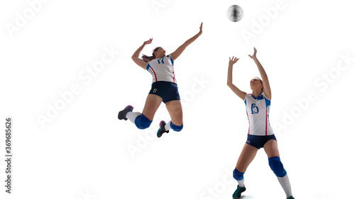 Female professional volleyball players in action on white background. © VIAR PRO studio