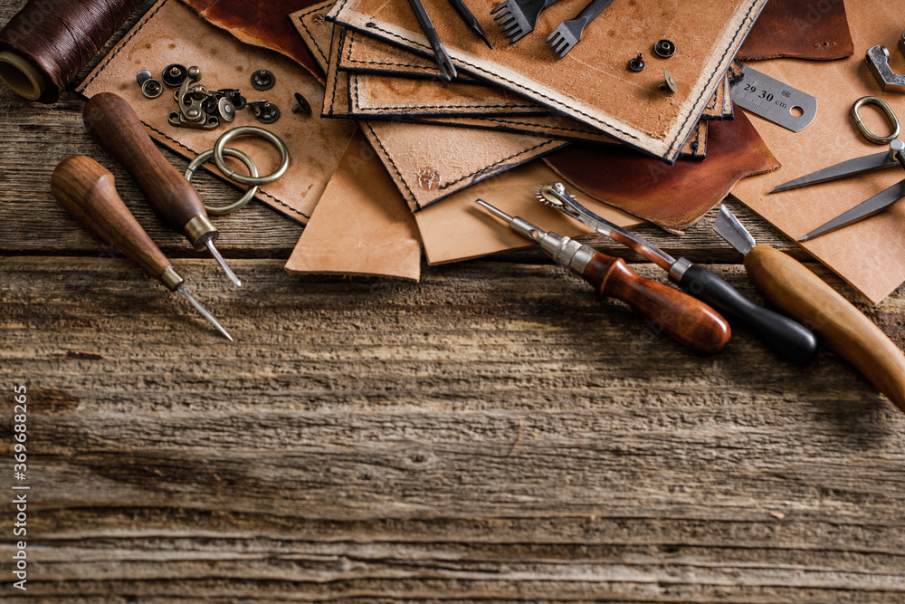 Leather craft tools on old wood table. Leather craft workshop