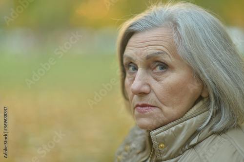 Portrait of sad, thoughtful senior woman in park