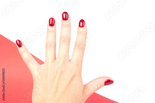 Stylish trendy female manicure. red manicure nails on red and white background