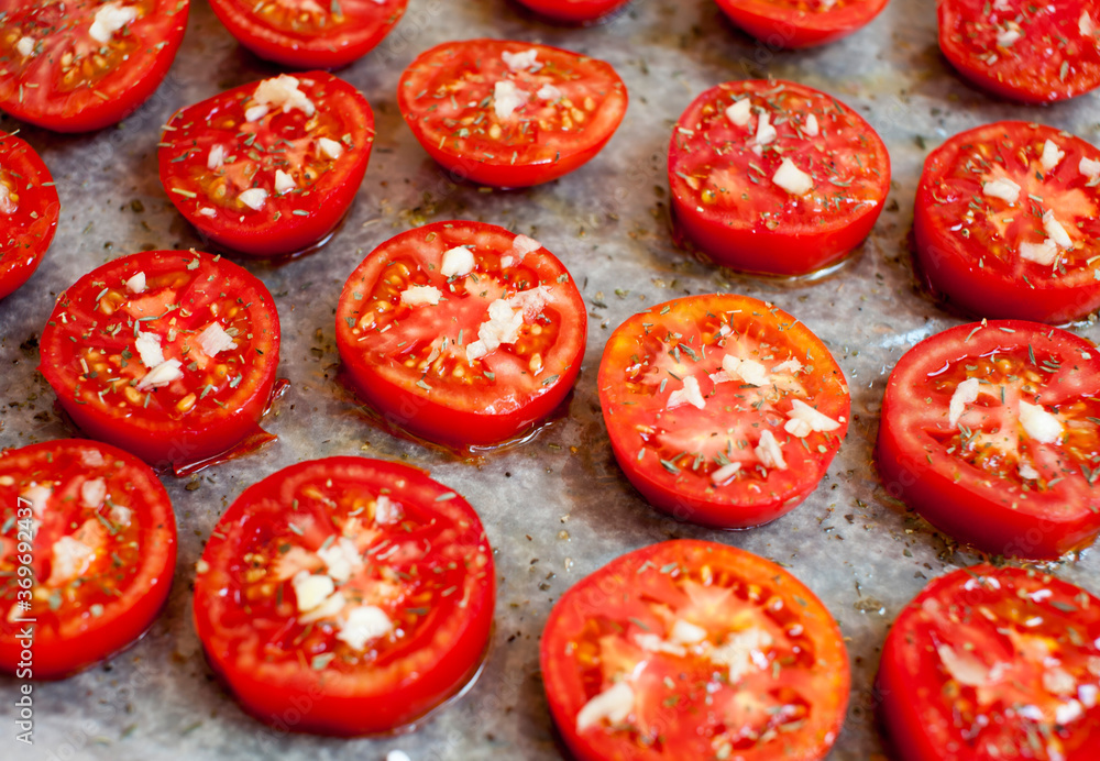 Chopped tomatoes with spices, garlic and olive oil on parchment paper. Close-up. Sun-dried tomatoes Chopped tomatoes with spices, garlic and olive oil on parchment paper. Close-up. Sun-dried tomatoes