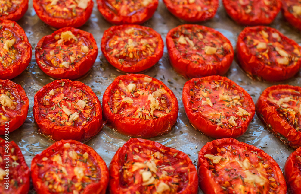 Lots of chopped sun-dried tomatoes with spices, garlic and olive oil on parchment paper. Close-up Lots of chopped sun-dried tomatoes with spices, garlic and olive oil on parchment paper. Close-up