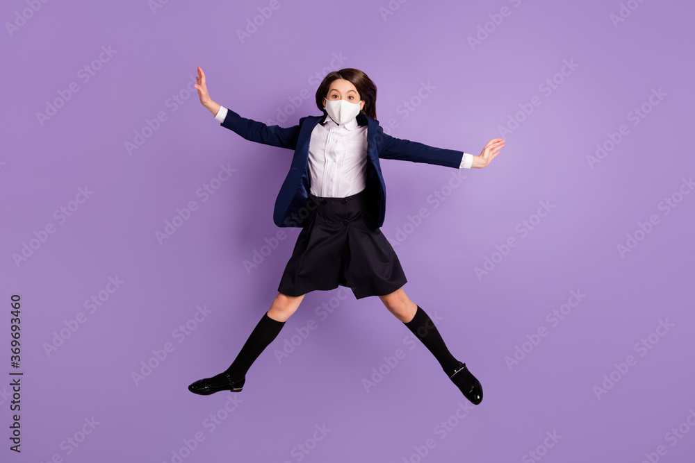 Full length body size view of her she active funky small little long-haired girl jumping wearing safety mask having fun pandemia isolated lilac violet pastel color background