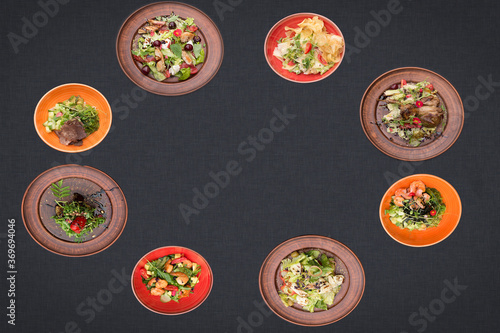 many salads on a black background lie in a circle with sopy space photo