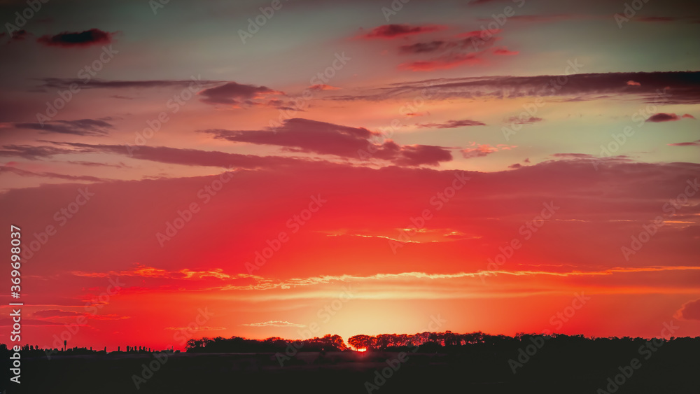 A dramatically bright and beautiful red sunset on a summer evening. A dramatically bright and beautiful red sunset on a summer evening.