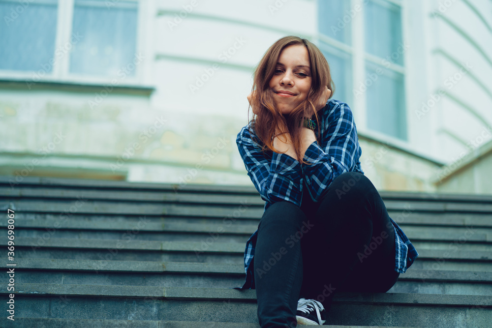 Young pretty woman poses on stairs of manor. Adult smiley female sitting on steps of Palace. Young pretty woman poses on stairs of manor. Adult smiley female sitting on steps of Palace.