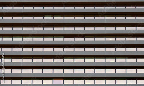 full frame image of a large commercial building with repeating rows of geometric windows