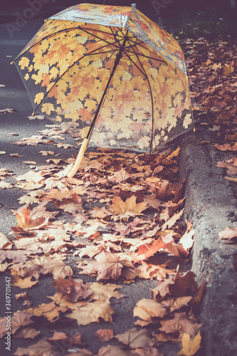 Foto Umbrella lies on the autumn leaves