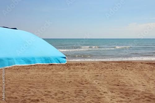 beach umbrella with sand and sea shore in summer