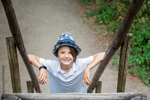 Portrait of a funny boy with hat standing on the bottom of the staircase