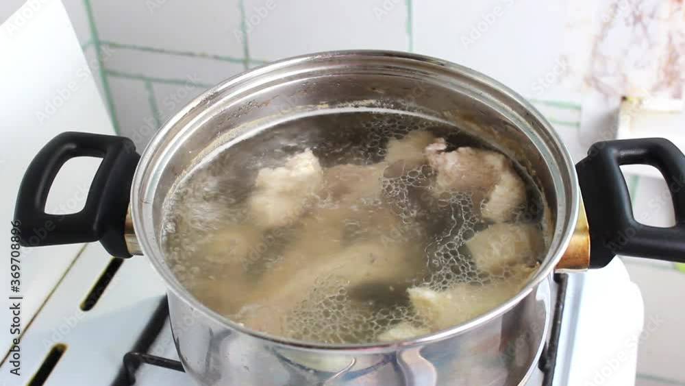 In a pot on a gas stove, boiling meat broth is cooked. Cooking at home. In a pot on a gas stove, boiling meat broth is cooked. Cooking at home.