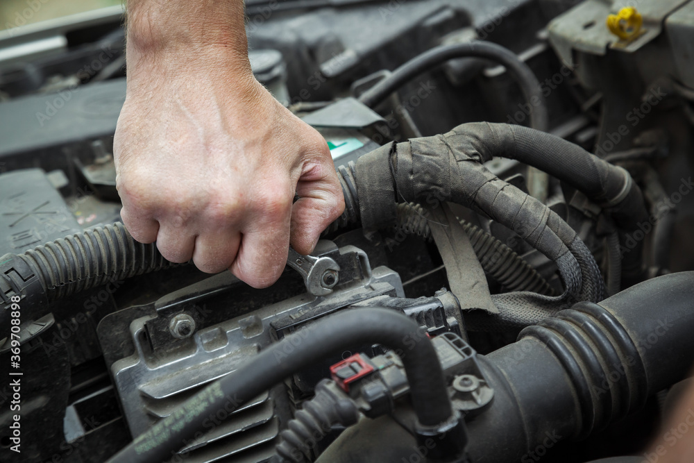 Close-up Of Hand Repairing Car Engine. Close-up Of Hand Repairing Car Engine.