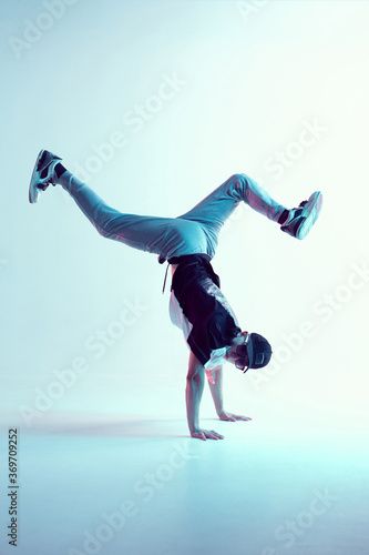 Stylish breakdancer stands on hands dancing hip-hop in neon light. Dance school poster. Battle competition announcement