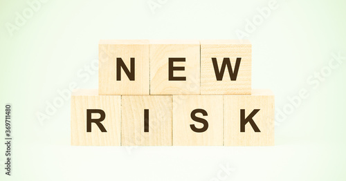 words new risk made with small wooden blocks on light green