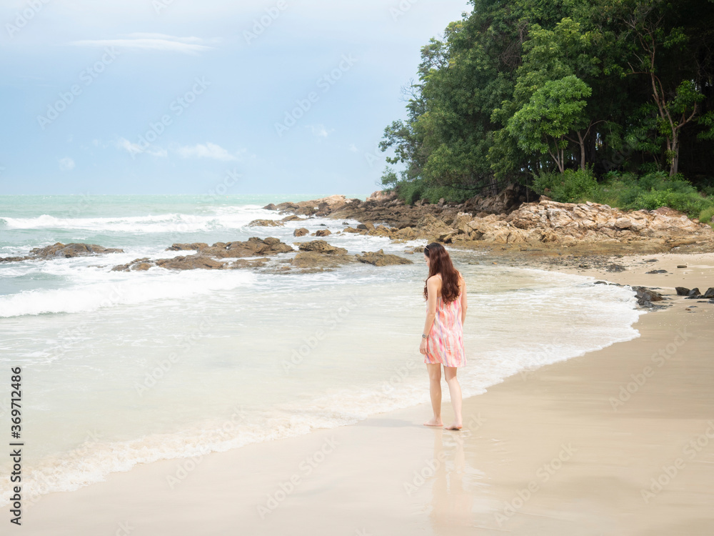asian woman in pink dress walking on beautiful beach at Samed, Thailand. asian woman in pink dress walking on beautiful beach at Samed, Thailand.