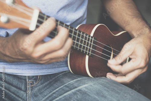 A young man playing the ukulele, Concept music player