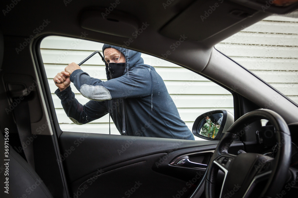 The criminal is trying to hack the car. Car thief. The criminal is trying to hack the car. Car thief.
