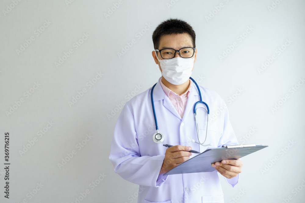 Male asian doctor working in the office hospital wearing face mask protect Covid 19 viruses. Healthcare And Medical concept. Male asian doctor working in the office hospital wearing face mask protect Covid 19 viruses. Healthcare And Medical concept.