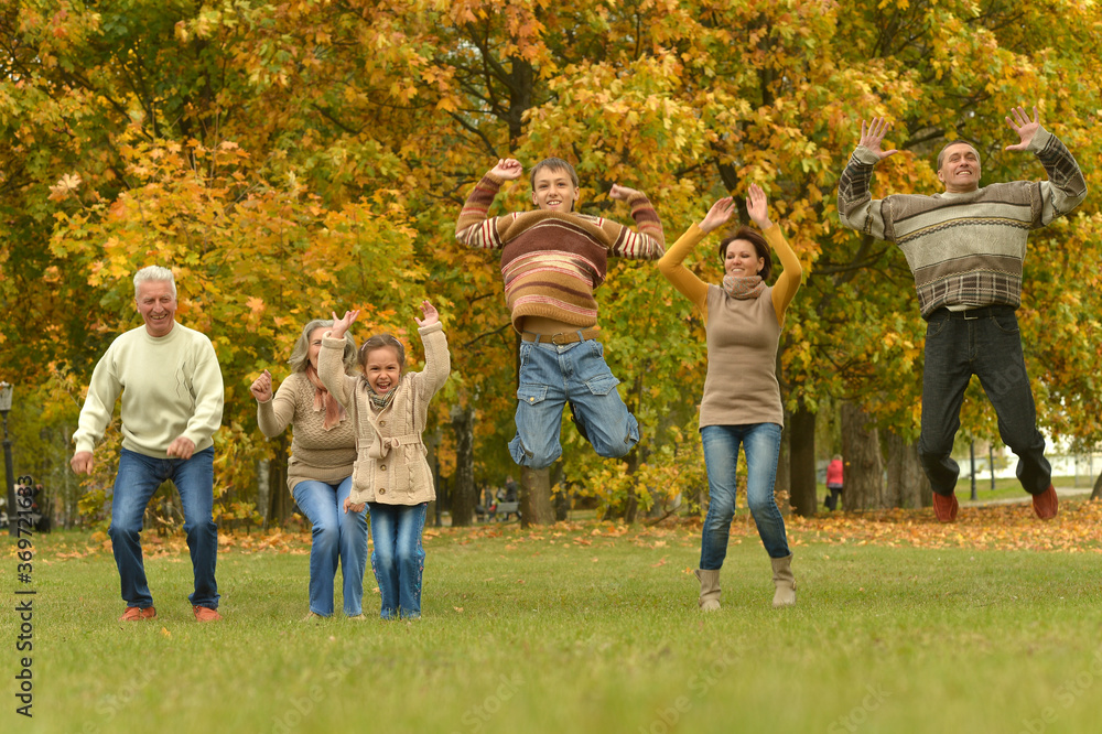 Fototapeta premium Happy smiling family relaxing in autumn park jumping