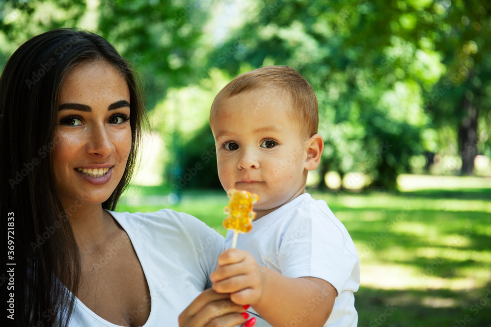 young pretty brunette mother with little cute boy walking in park happy smiling, lifestyle people concept young pretty brunette mother with little cute boy walking in park happy smiling, lifestyle people concept