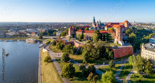 Krakow, Poland. Wide aerial panorama at sunset with Royal Wawel castle and cathedral. Vistula river banks, tourist boats, parks, promenades and walking people © kilhan