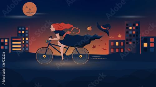 Halloween. Joyful witch rides a bicycle through the night city