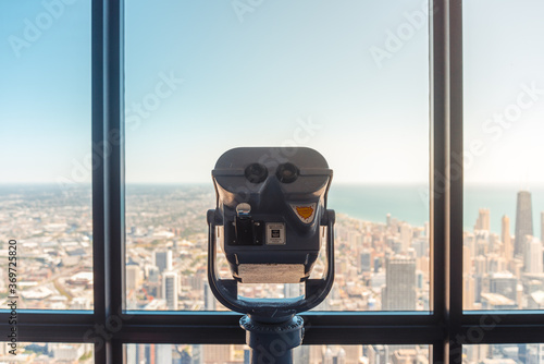 coin-operated binocular on top of the building looking into the city photo