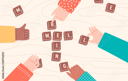 Group of people playing board game, hands collecting words from game pieces on wooden table. Well being, home activity or friendship concept.