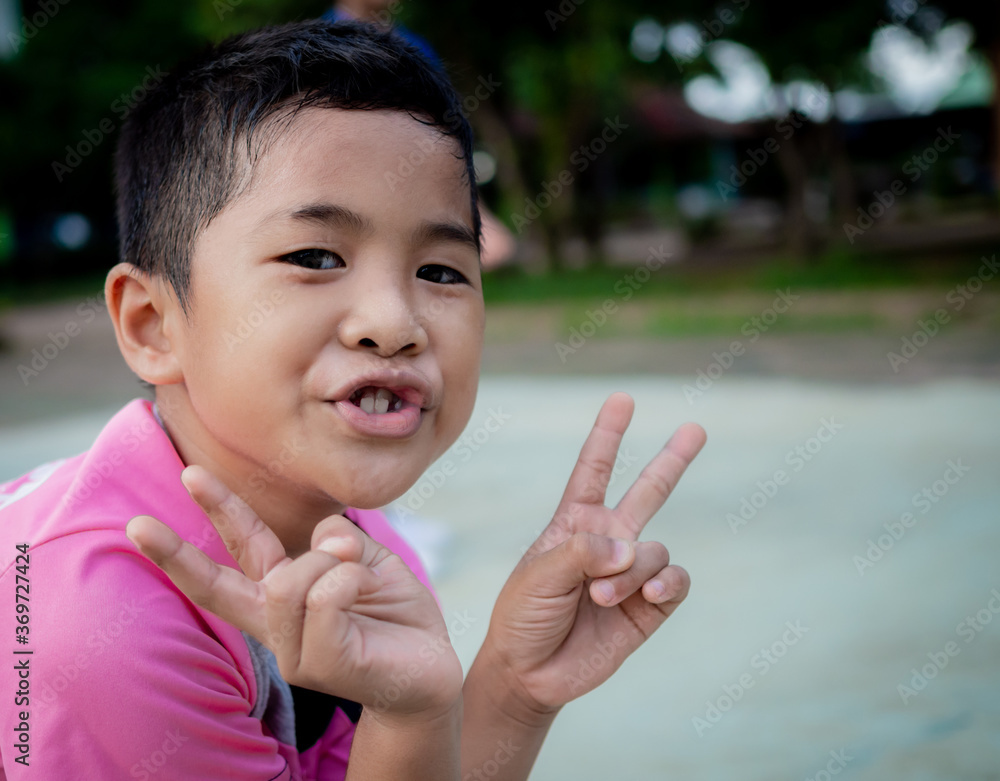 A close-up of the little boy smiling happily in the park. A close-up of the little boy smiling happily in the park.