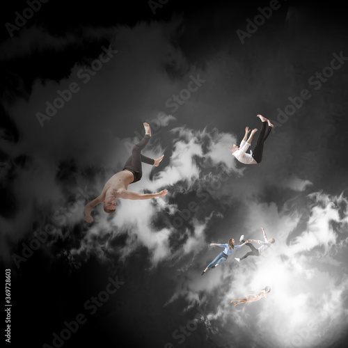 Mid-air beauty cought in clouds. Full length shot of attractive young woman and man hovering in air and keeping eyes closed. Levitating in free falling, lack of gravity. Freedom, emotions, artwork
