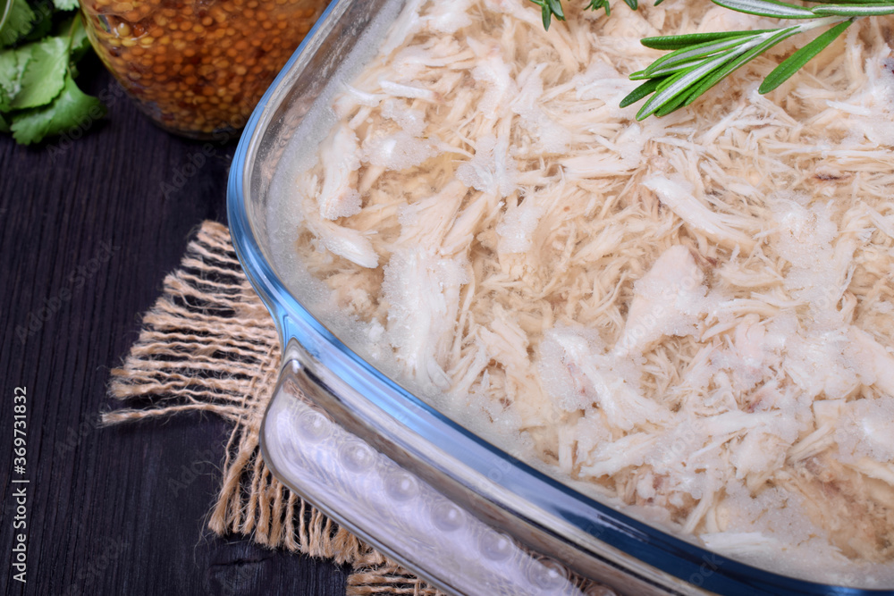 Holodets chicken meat jelly in a glass dish and a jar of mustard Stock