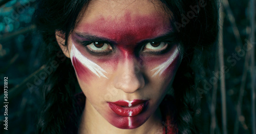 Foto red-skinned Indian girl with red makeup on her face posing in yellow grass