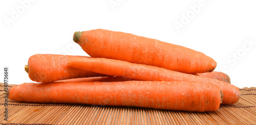Carrot tubers isolated on bamboo background