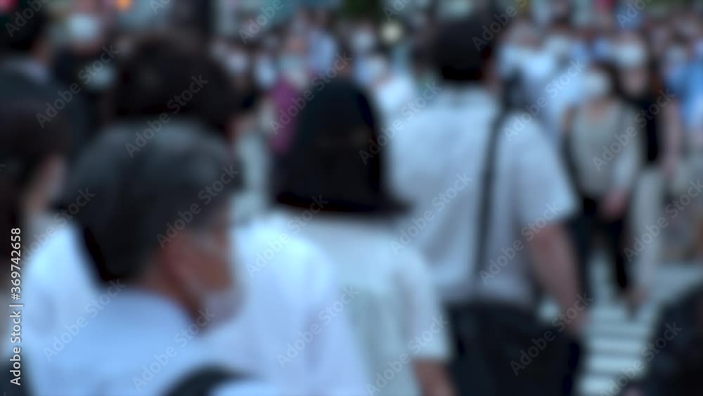 TOKYO, JAPAN - JUL 2020 : Crowd of people at the street near Shinjuku station in rush hour. Commuters wearing surgical mask to protect from Coronavirus (COVID-19) in hot summer season. Blurred shot. TOKYO, JAPAN - JUL 2020 : Crowd of people at the street near Shinjuku station in rush hour. Commuters wearing surgical mask to protect from Coronavirus (COVID-19) in hot summer season. Blurred shot.