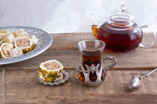 Turkish tea in a traditional cup on a wooden table. Tea drinking with oriental sweets and a fragrant drink.