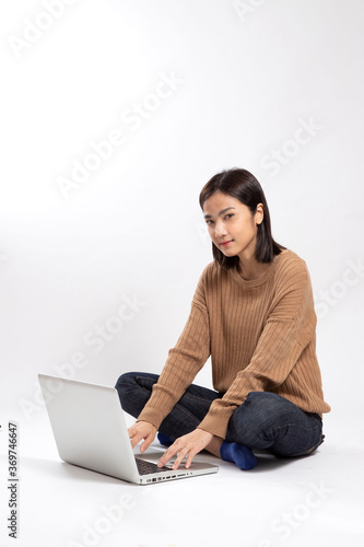 The Asian woman sitting on the white background.