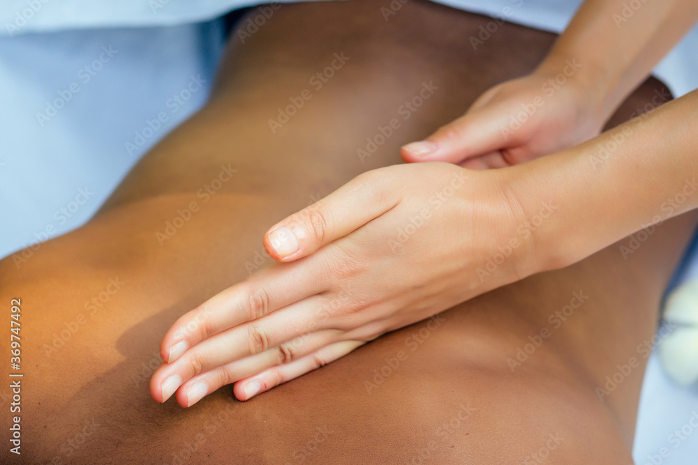 brazilian woman getting back and shoulders massaging in outdoor spa Ayurveda centre in India green tropical background brazilian woman getting back and shoulders massaging in outdoor spa Ayurveda centre in India green tropical background