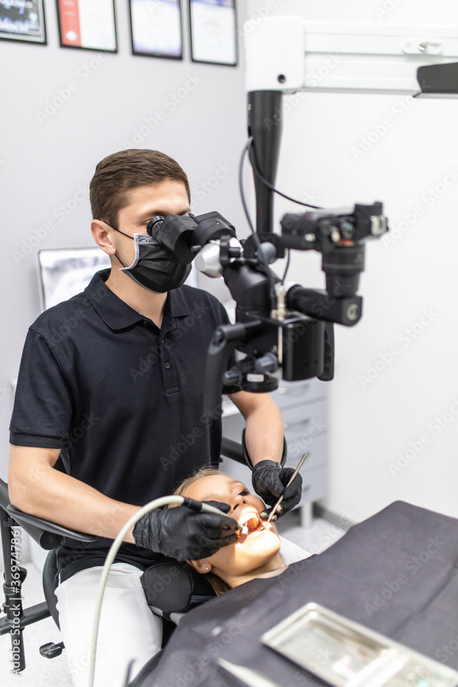 The dentist examines the patient's teeth with a dental microscope. Modern medical equipment The dentist examines the patient's teeth with a dental microscope. Modern medical equipment