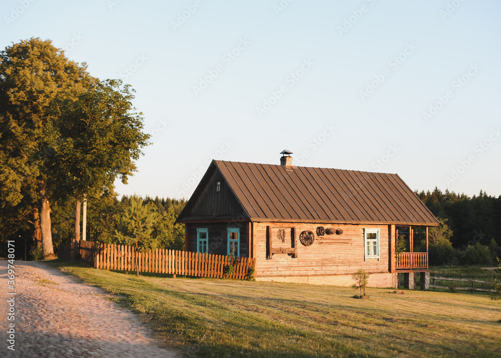 old wooden house in village. Farmhouse in Belarus. View of rustic ethnic house on sunset. rural landscape old wooden house in village. Farmhouse in Belarus. View of rustic ethnic house on sunset. rural landscape