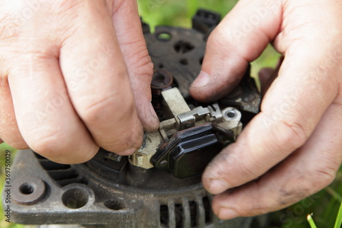 Canvas Print Used car 12 V alternator removing relay voltage regulator in hands close up, out