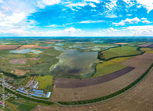 Liman Lebyazhy near the Limansky farm (South of Russia, Krasnodar Territory) surrounded by plain fields, lakes and estuaries of the Beysug river - aerial dvron panorama on a hot summer sunny day
