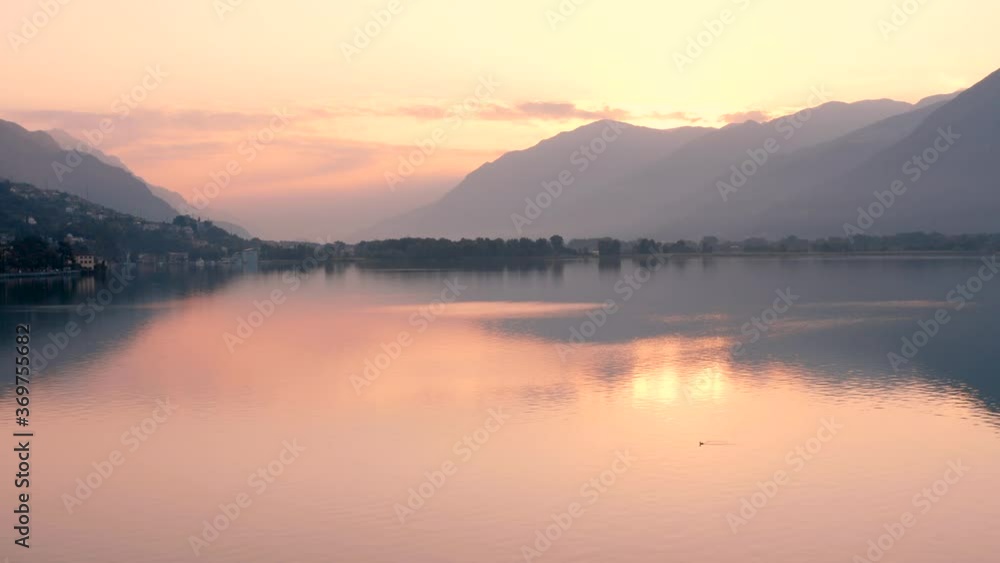 Drone view of Lake Iseo at sunrise, on the left the city of lovere which runs along the lake,Bergamo Italy. Drone view of Lake Iseo at sunrise, on the left the city of lovere which runs along the lake,Bergamo Italy.