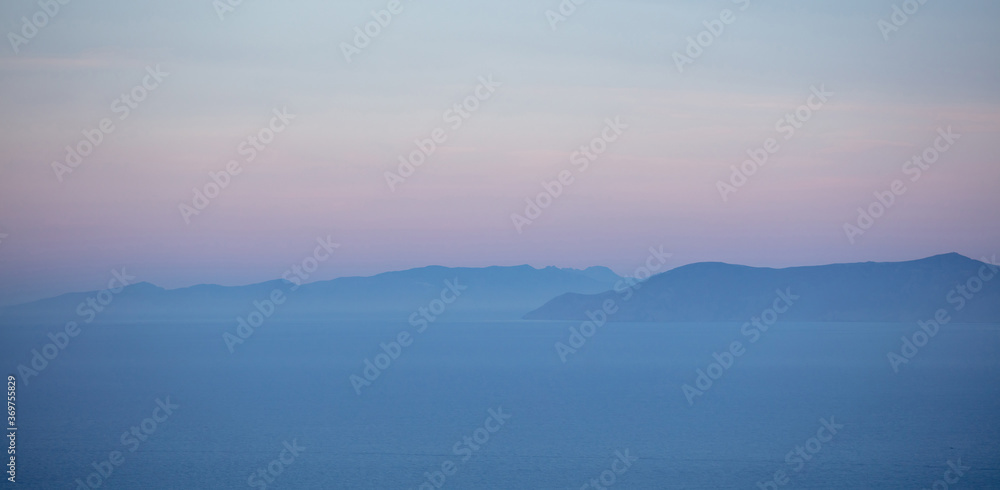 Aegean sea and Attica Greece hills, pastel blue and pink shades on sea and sky background,