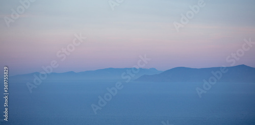 Aegean sea and Attica Greece hills  pastel blue and pink shades on sea and sky background 