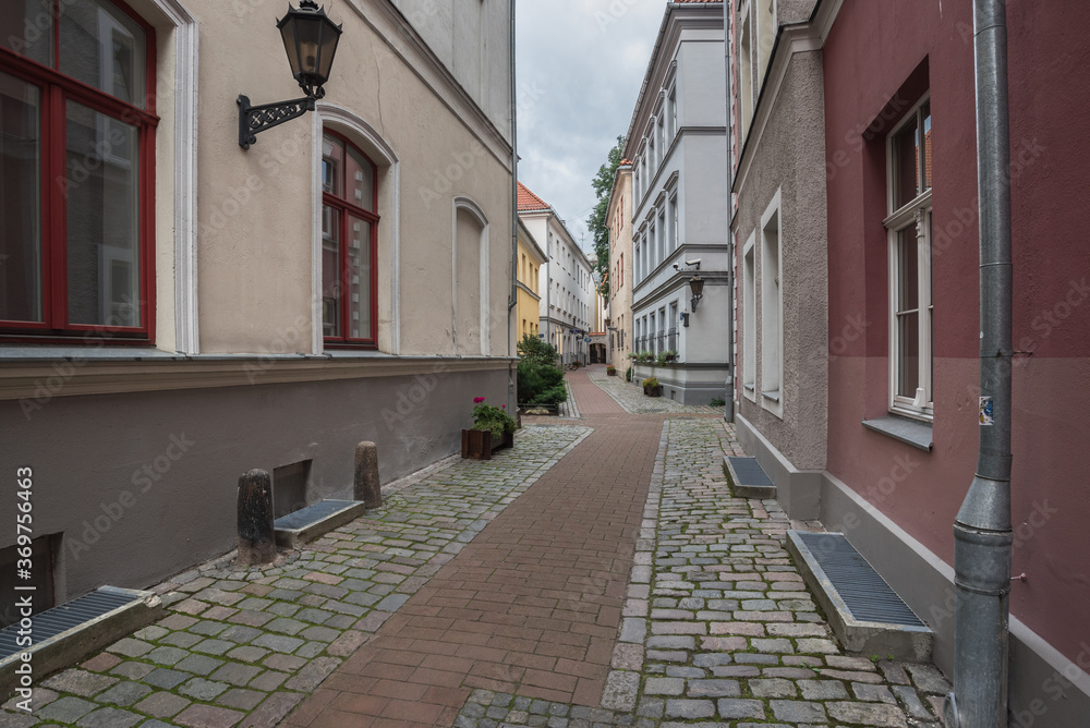 Picturesque street in Old Town of Riga, colorful, well preserved, historic buildings, cobble stones paved and winding narrow street, Riga, Latvia.