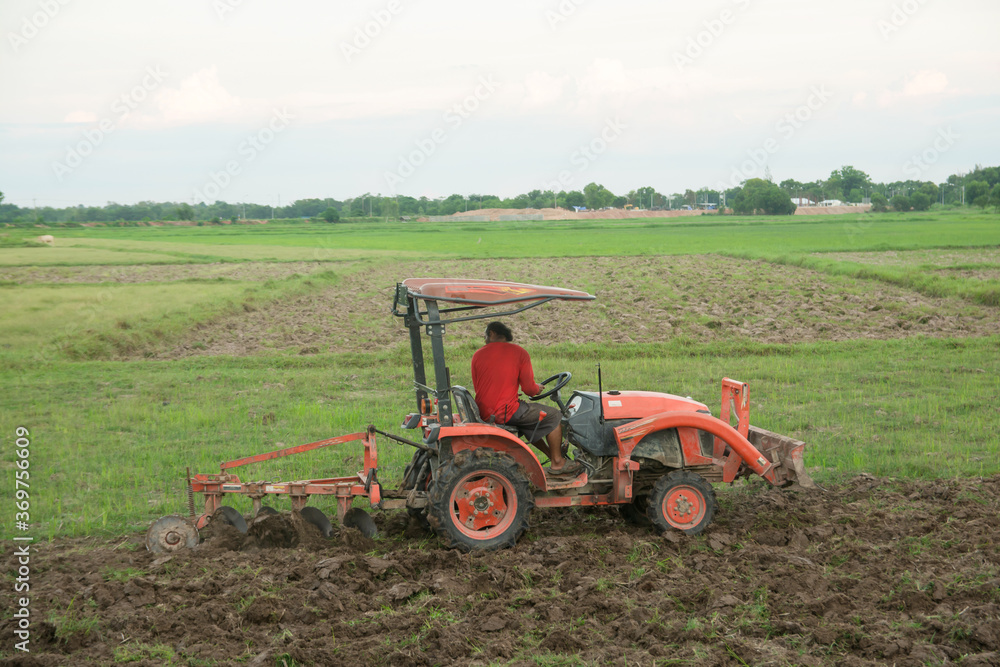 Tractor working plows a field on the farm for planting. Tractor working plows a field on the farm for planting.