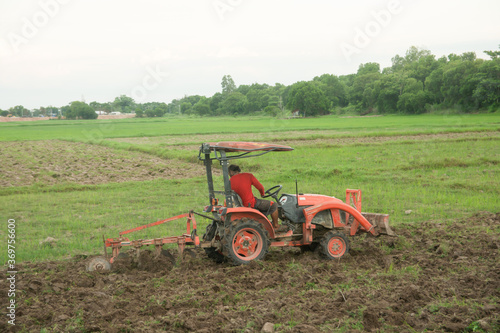 Tractor working plows a field on the farm for planting.