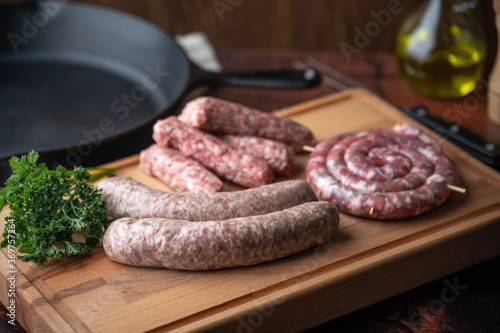 fresh sausages on wooden cutting board